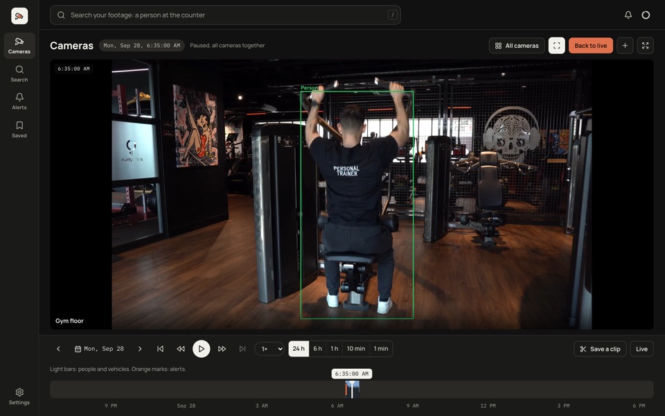 The RememberCam app showing a gym floor camera: a person on a pulldown machine, in a green box.